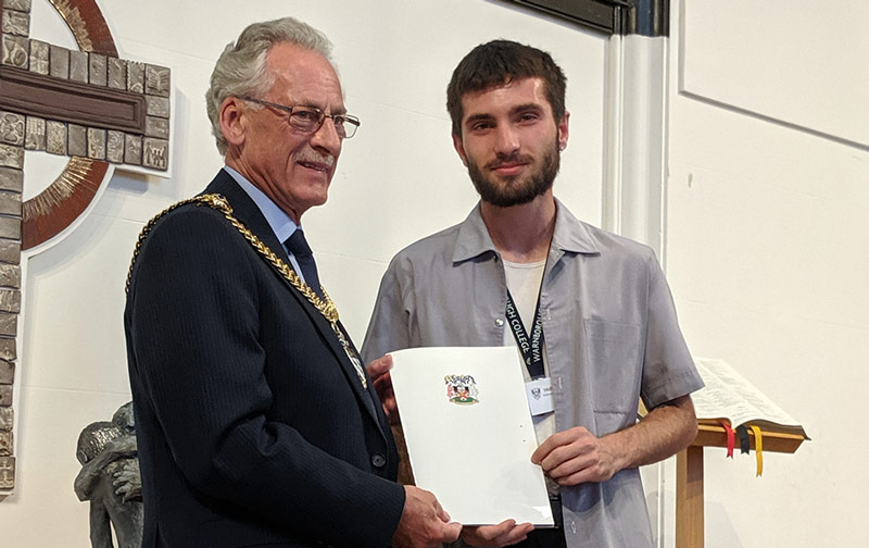 Valentin receives his certificate from the Mayor